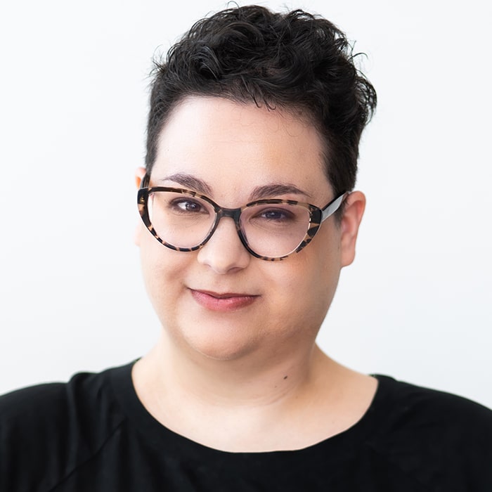 Person with cropped hair wearing glasses / Ophira Calof