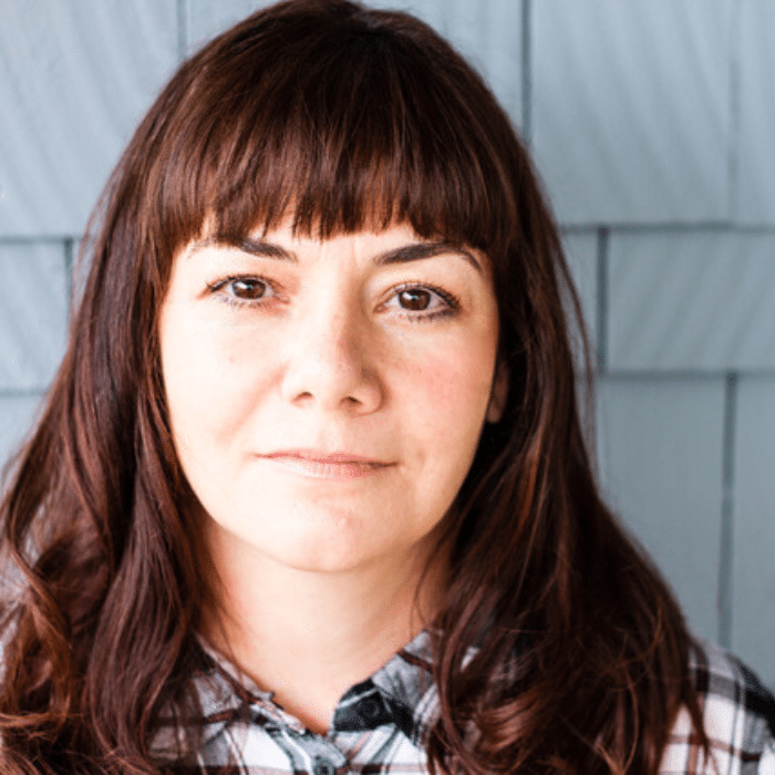 Cheryl Binning with long auburn hair with bangs, wearing a flannel shirt.